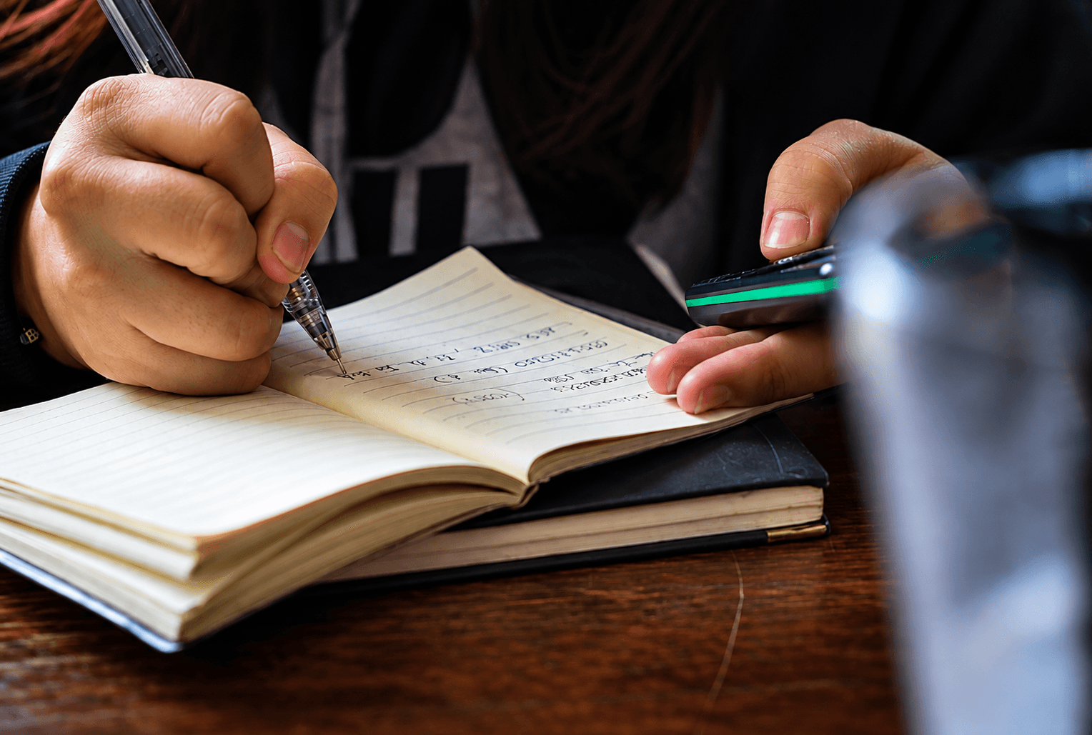 A student writing notes in an open notebook